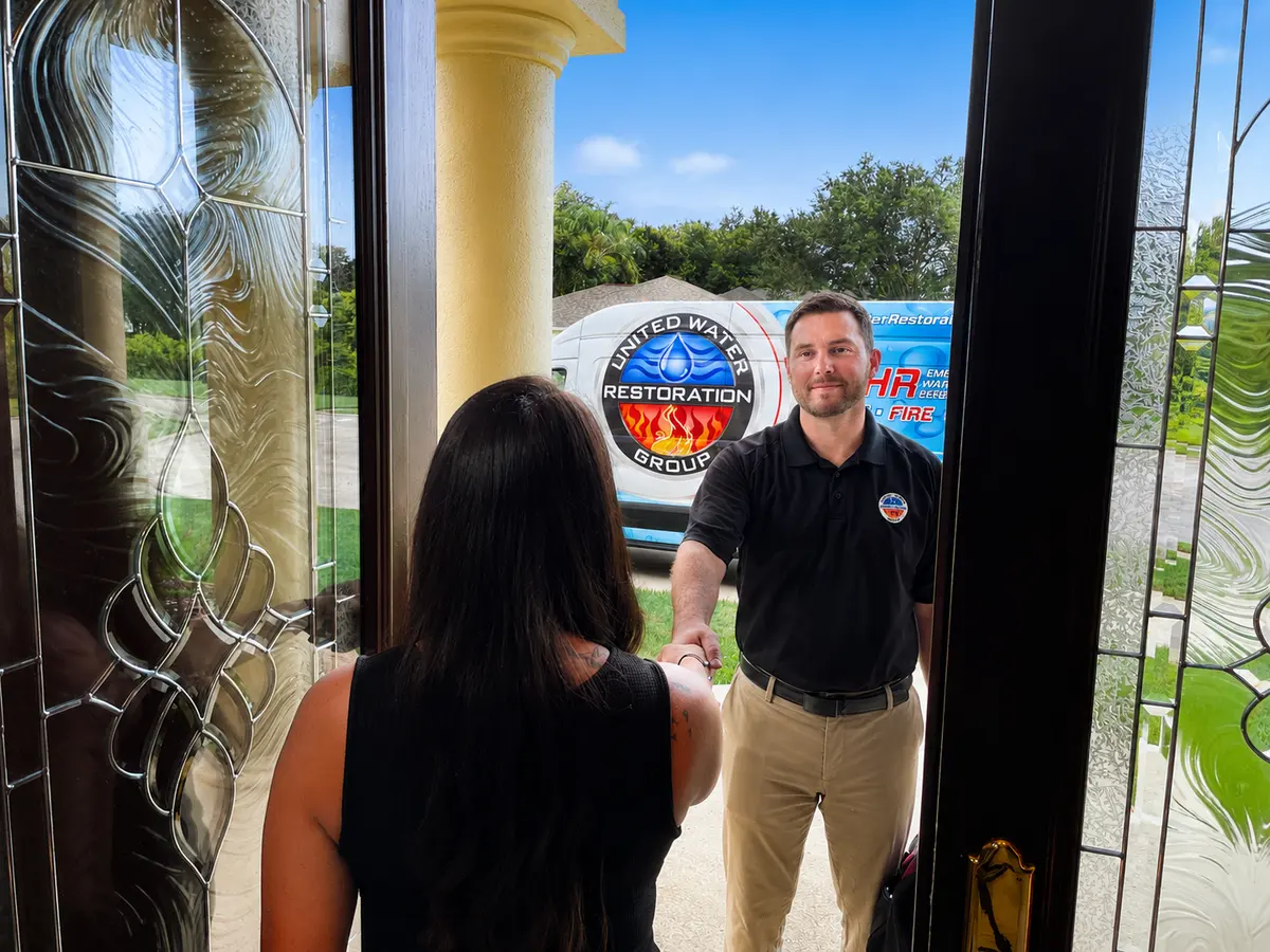 A technician arriving at a homeowner’s front door to look at the damage